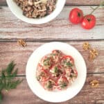 Eggplant Salad Stuffed Tomatoes in a white plate with fresh tomatoes on the side.