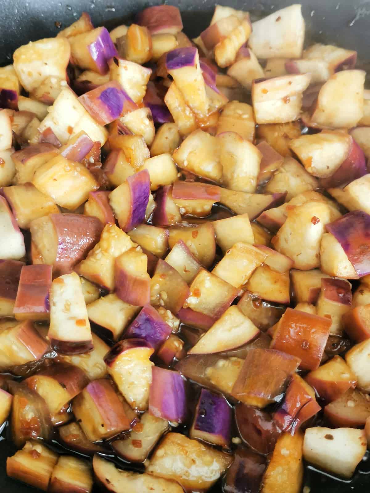 diced eggplants sauteing in pan, closeup.