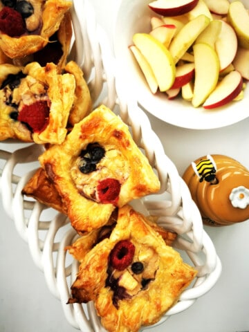 Honey Glazed Apple and Blueberry Pastry Cups with sliced appled and honey on the side