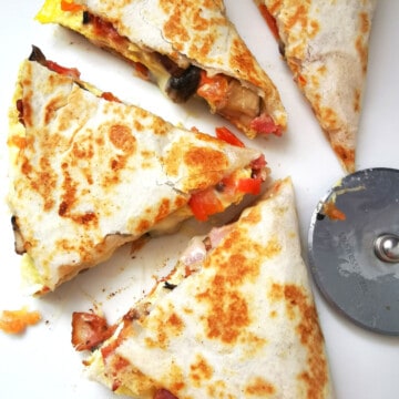 sliced Crispy Breakfast Quesadilla with pizza slicer on the side