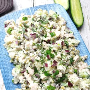 Olivier salad with cucumbers on a blue plate.