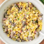 Corn and marinated mushroom salad in salad bowl with red onion and chives on the side