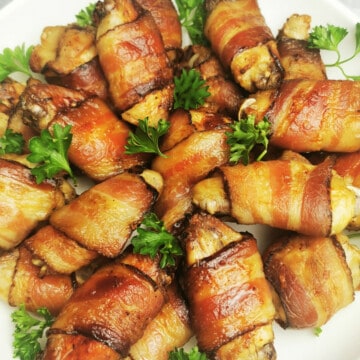 Maple Bacon-Wrapped Chicken Wings garnished with parsley and served on white platter