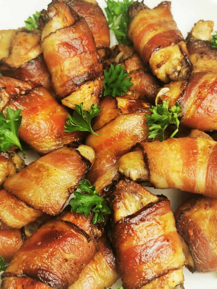 chicken wings wrapped in bacon with chopped parsley closeup