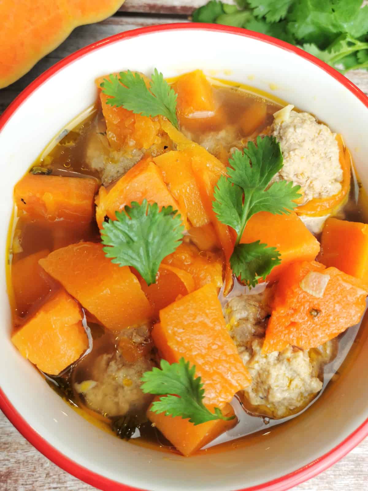 Meatball soup with sweet potatoes and butternut squash in a soup bowl.