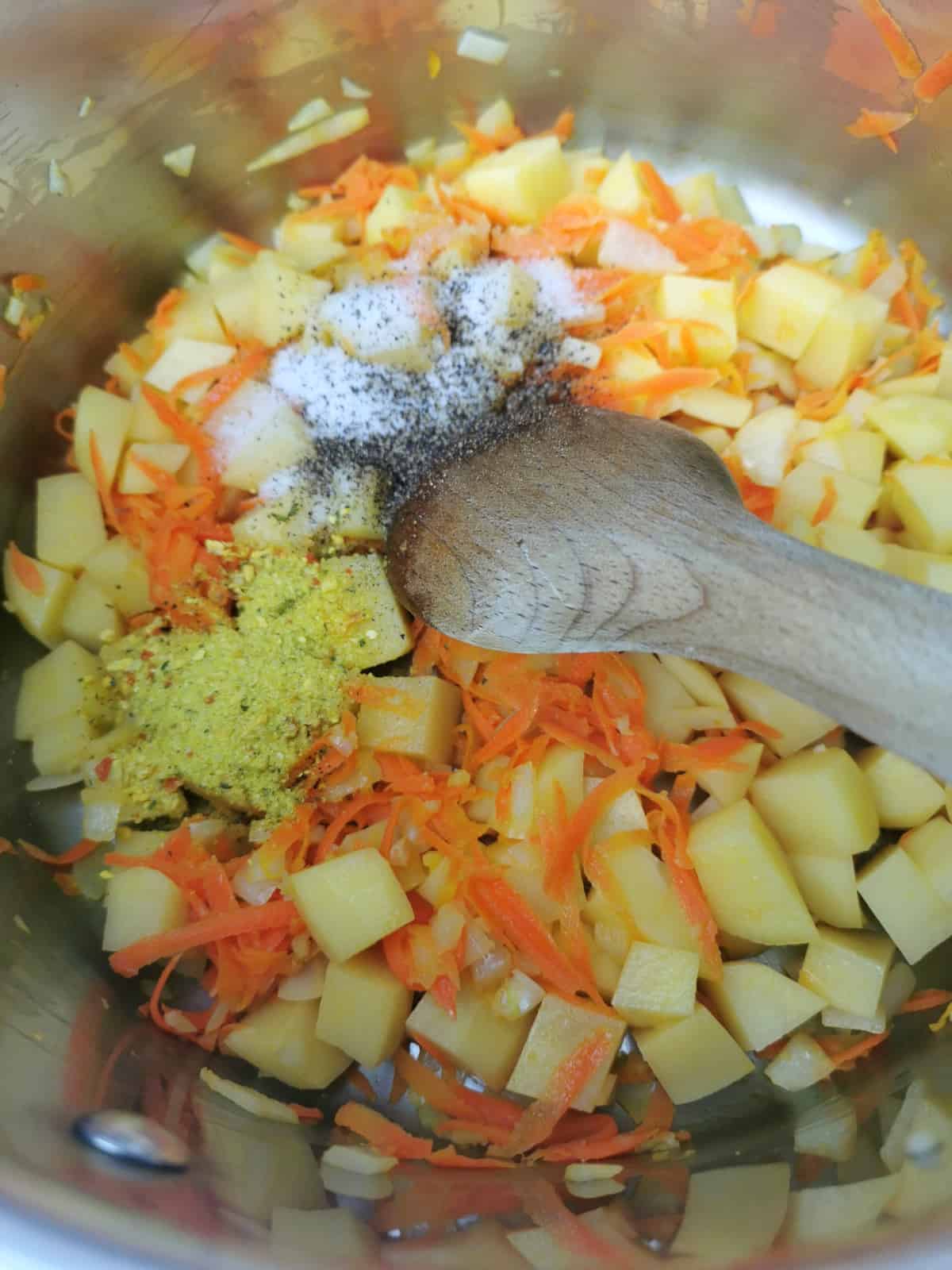 grated carrot, onion, garlic and potatoes sauteed in oil in a large soup pot.