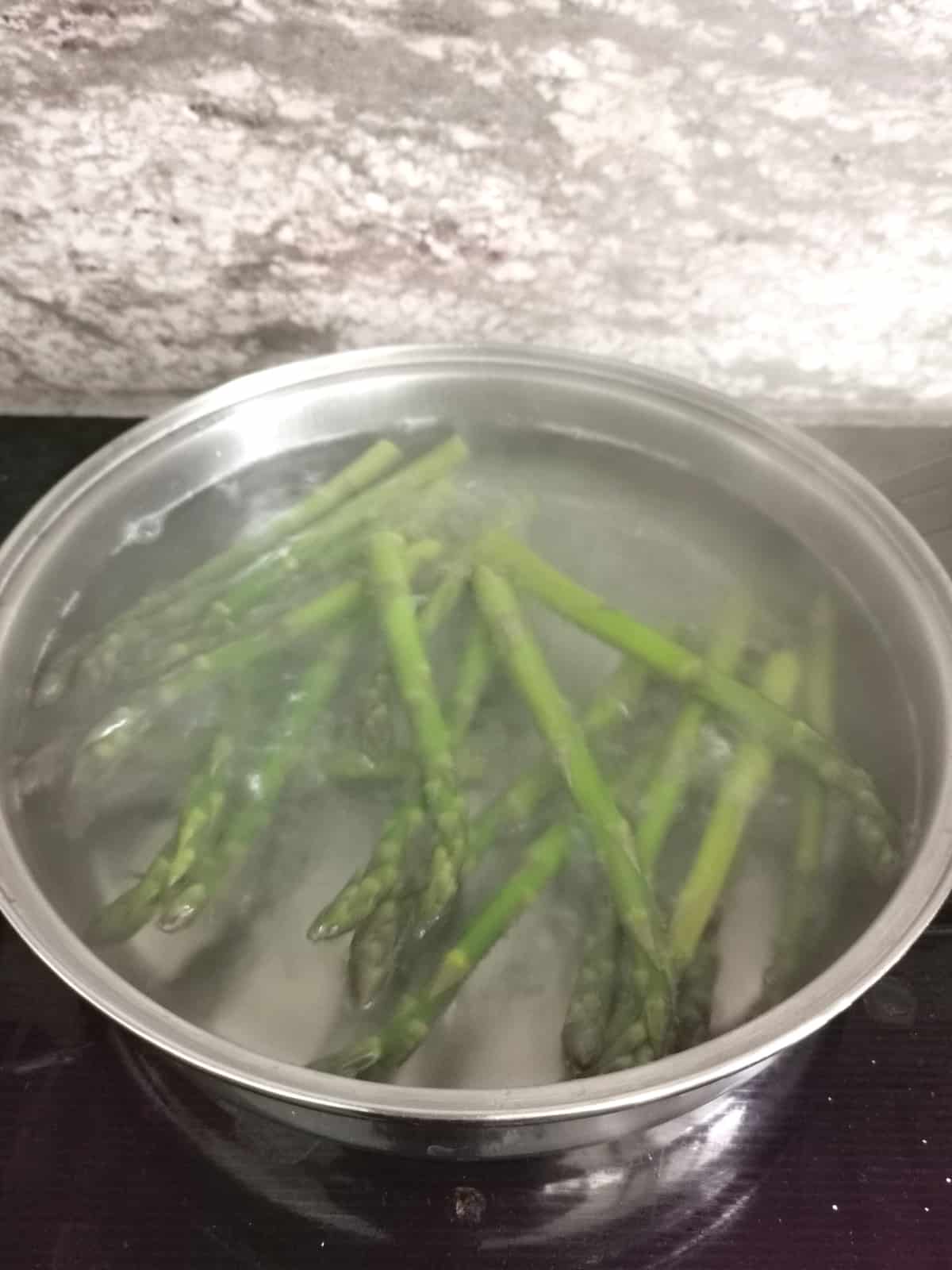 asparagus boiling a large pot on the stove.