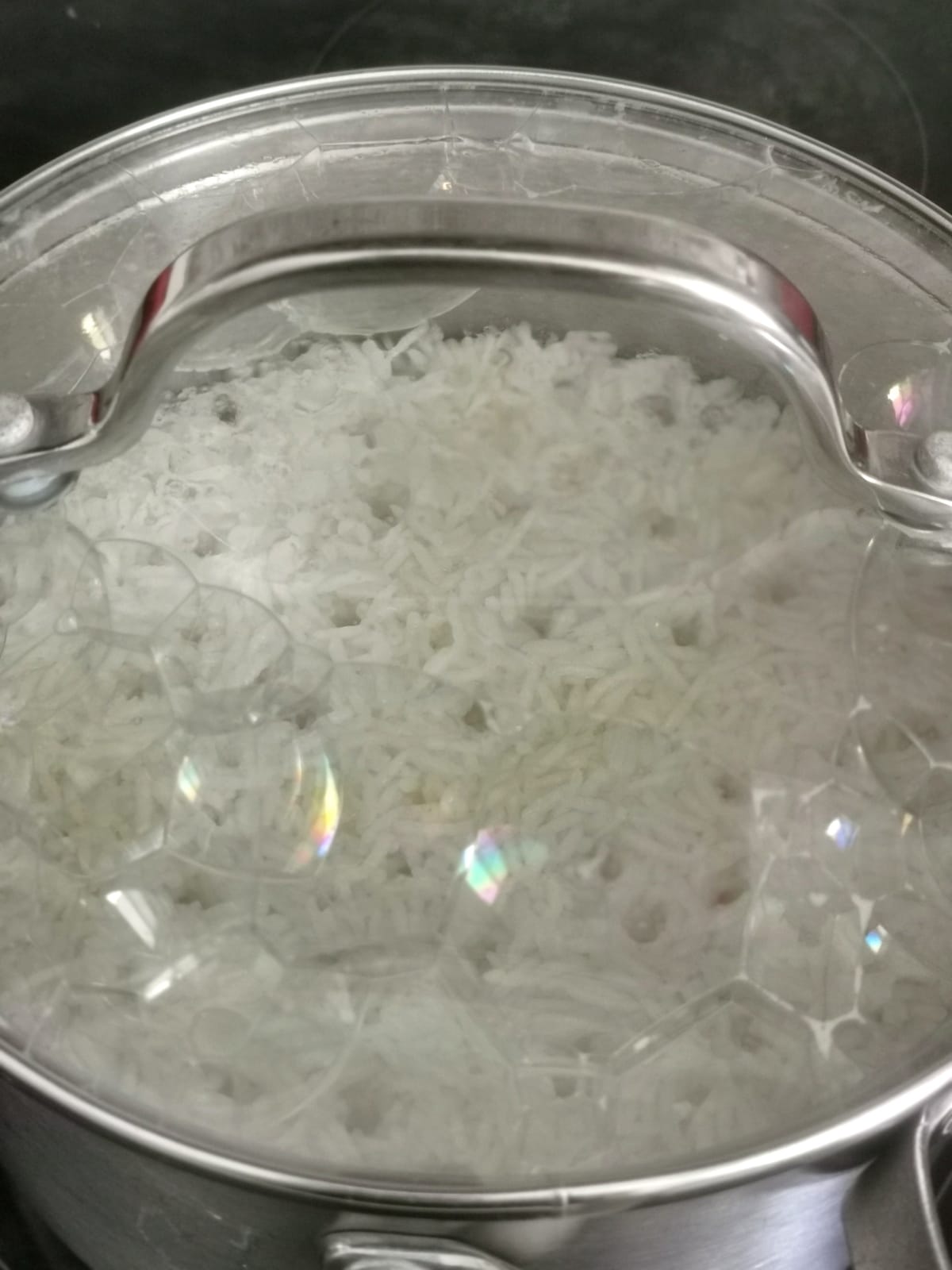cooked rice in a pot covered with a lid.