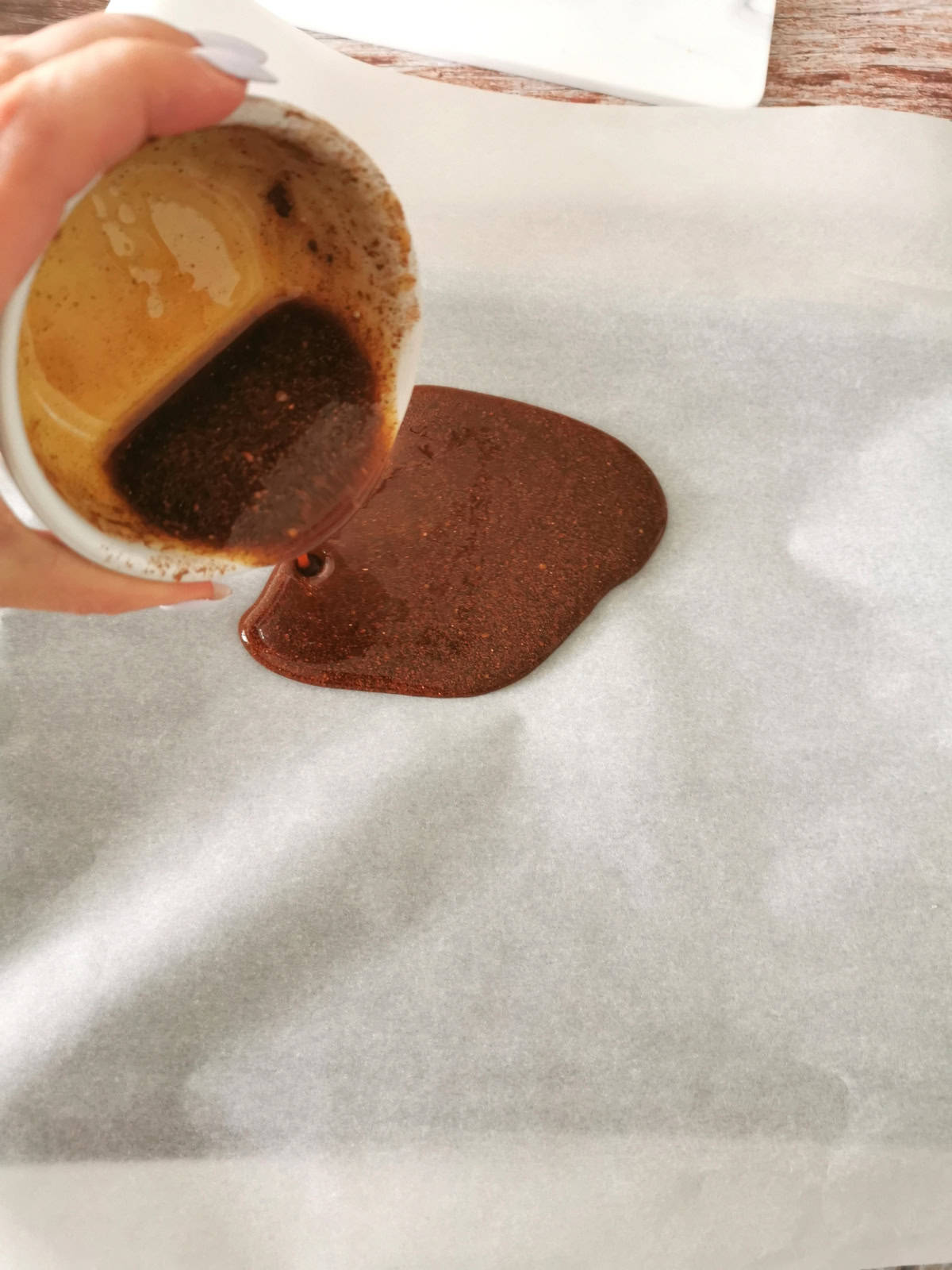 cinnamon and nutmeg syrup poured into parchment paper lined baking dish.