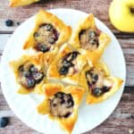 Honey-Glazed Apple and Blueberry Pastry Cups on a white serving plate.