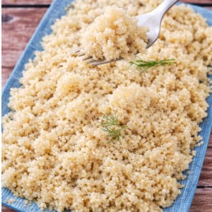 Close-up of fluffy cooked quinoa with perfect grain separation, lifted with a fork.