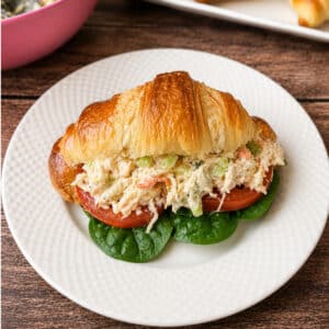 Croissant Chicken Salad Sandwich on a white plate.