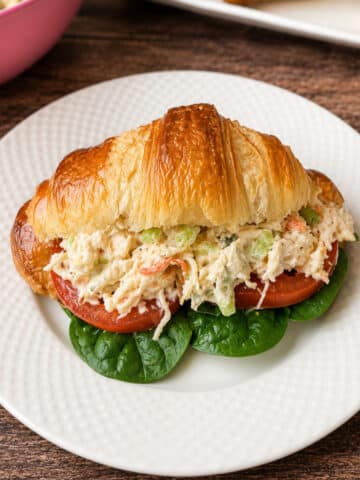 Croissant Chicken Salad Sandwich on a white plate.