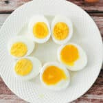 soft-boiled, medium-boiled, and hard-boiled eggs halved on a white plate.