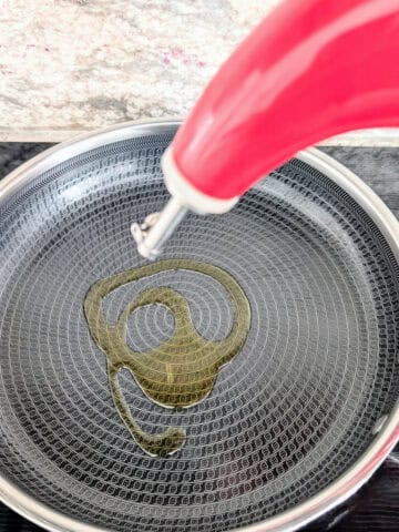 oil pouring into a pan on the stove.