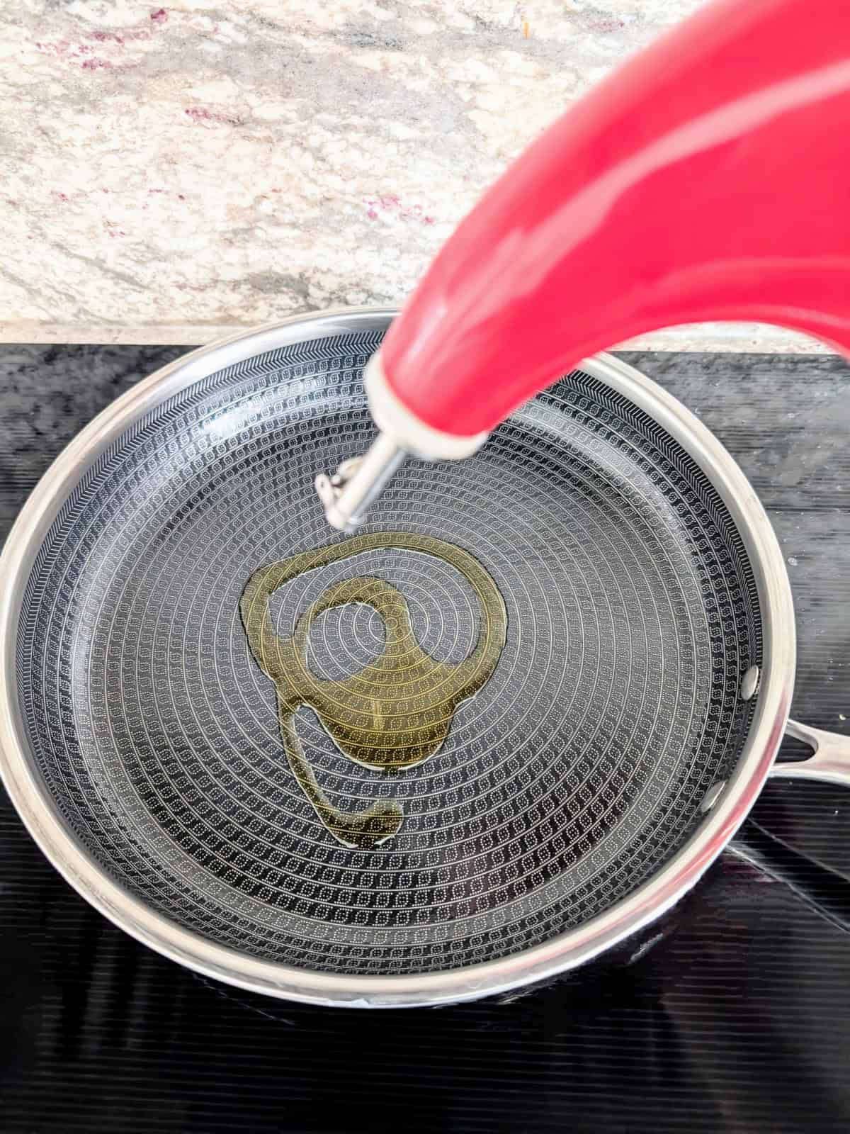 oil pouring into a pan on the stove.