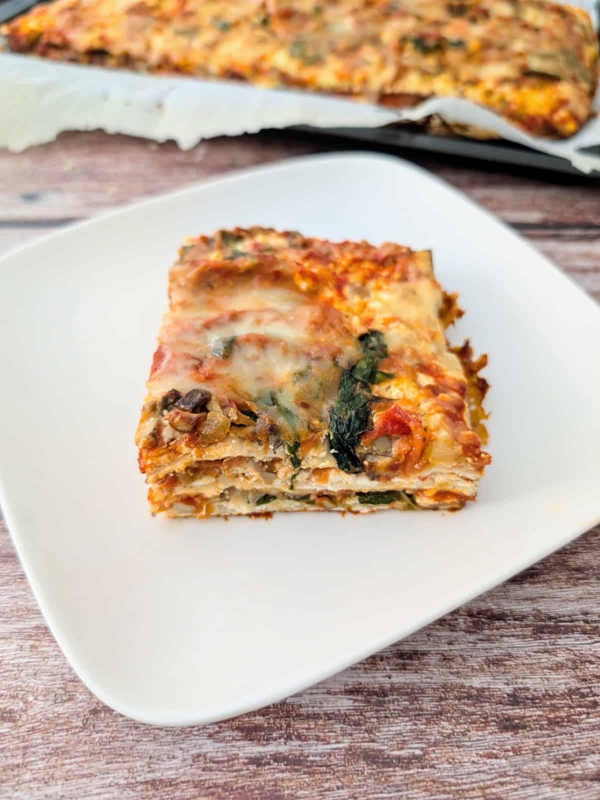 Matzo lasagna on a white square plate.