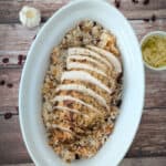 Tender Baked Turkey Breast over rice, in a white serving platter.
