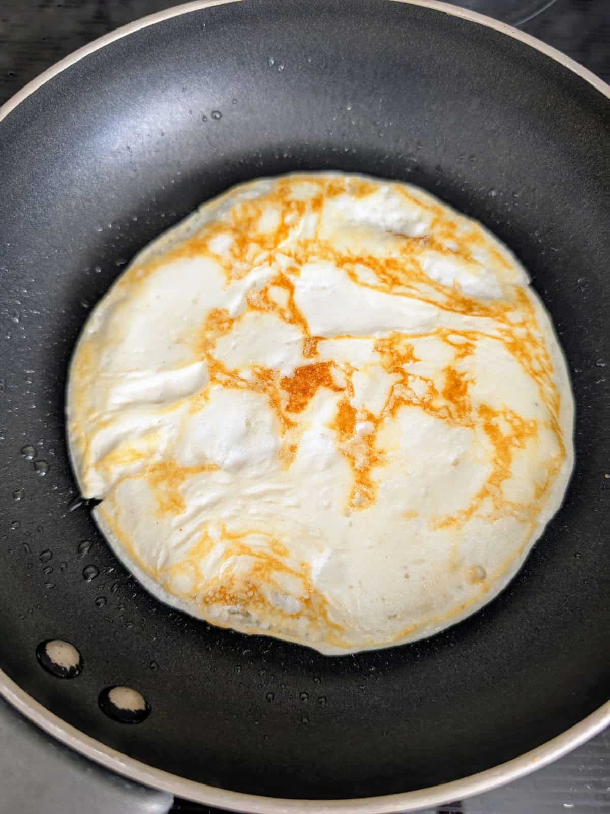 Cottage Cheese crepe cooking on a pan.