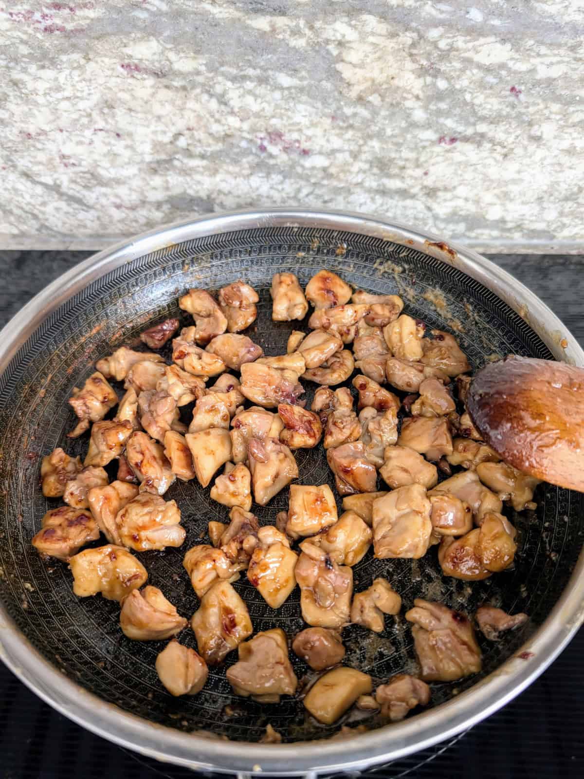 cooked honey-garlic chicken in a pan on the stove-top.