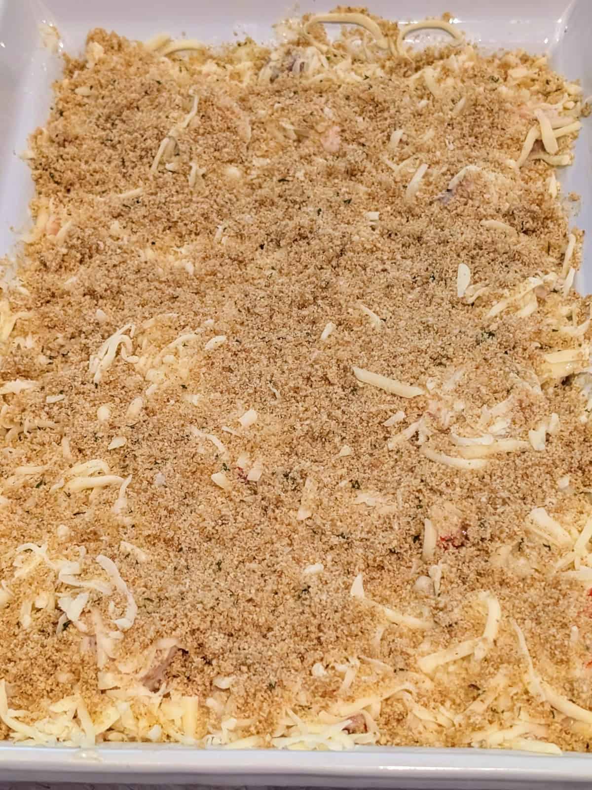 breadcrumb and butter mixture spread over cheese layer.