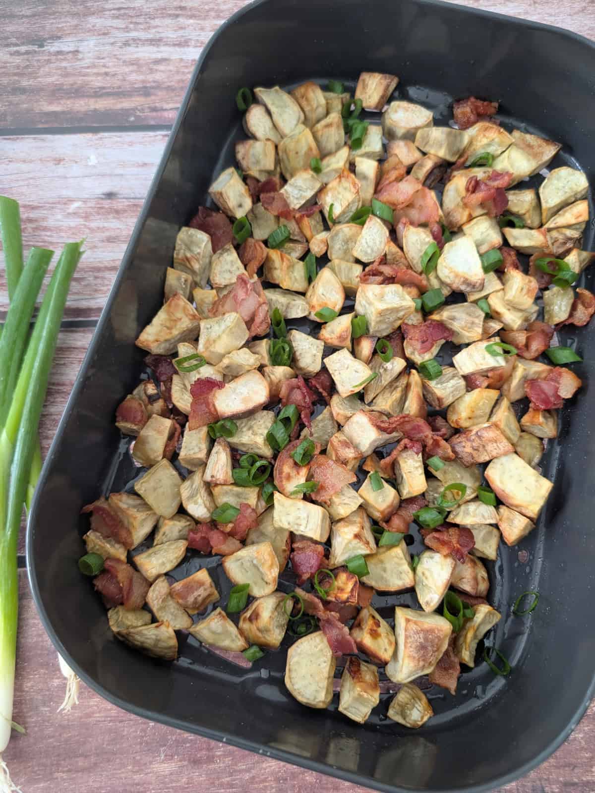 2-Ingredient Air Fryer Bacon Potatoes in an air-fryer tray.