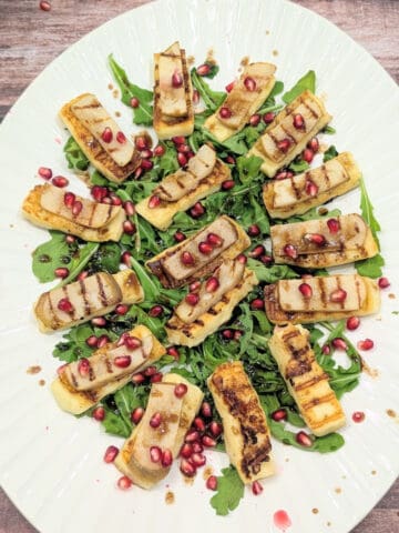 grilled halloumi with pear and honey on a large white platter.