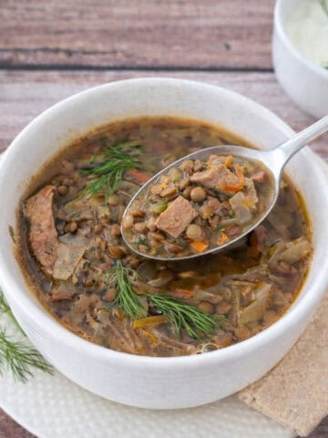 Turkey Lentil Soup with Cabbage & Bacon in a white bowl.