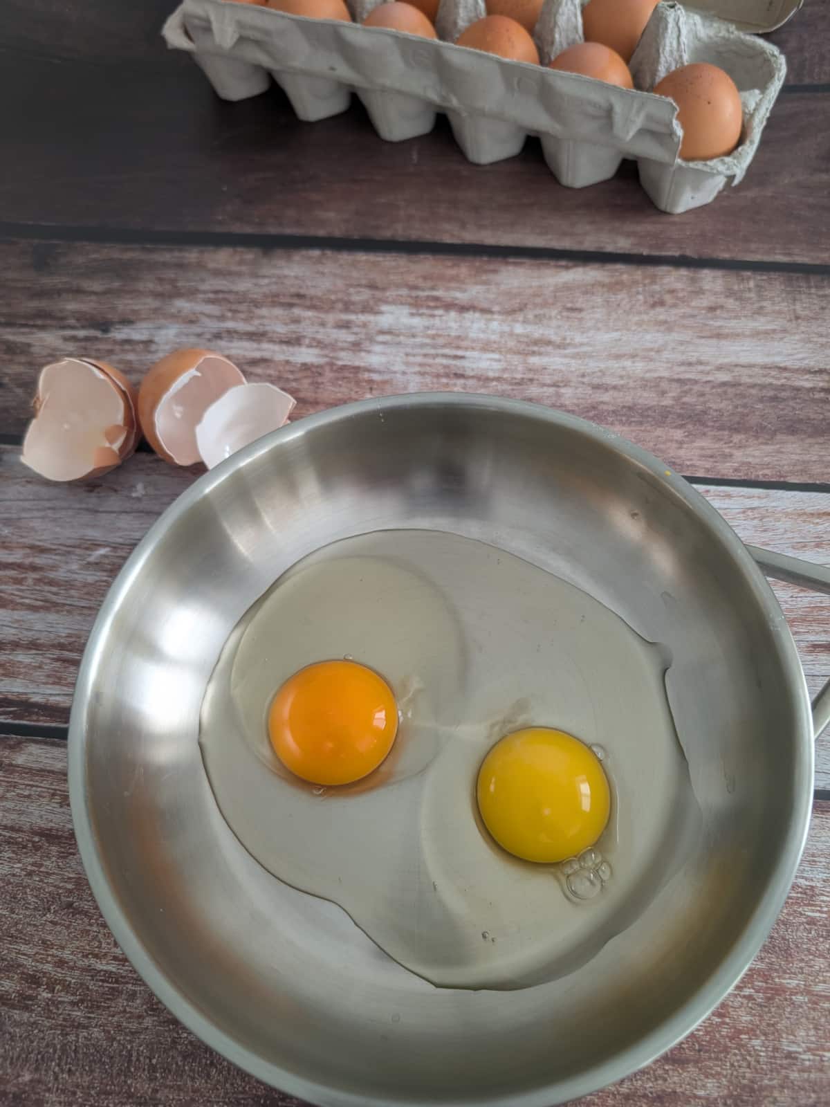 dark egg yolk color and light yellow egg yolk color in eggs cooking in a pan.