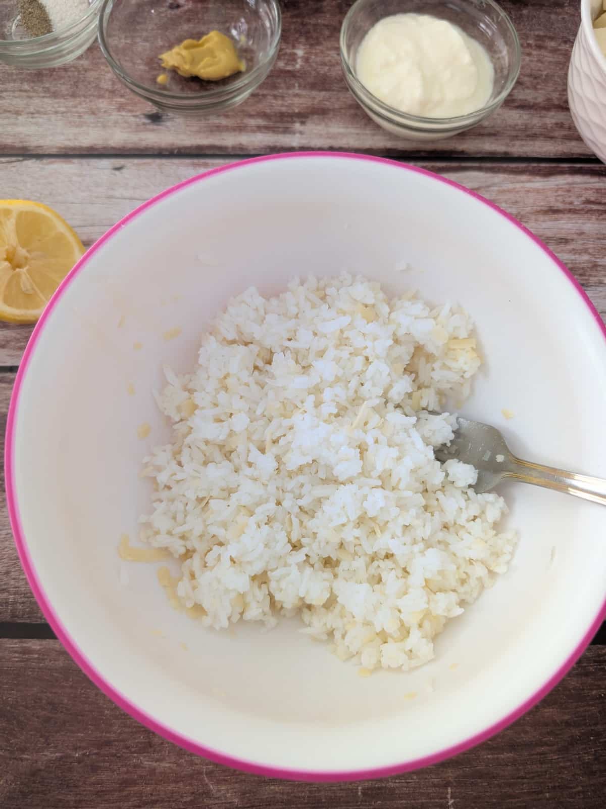 Mixing leftover rice with parmesan and olive oil in a bowl.