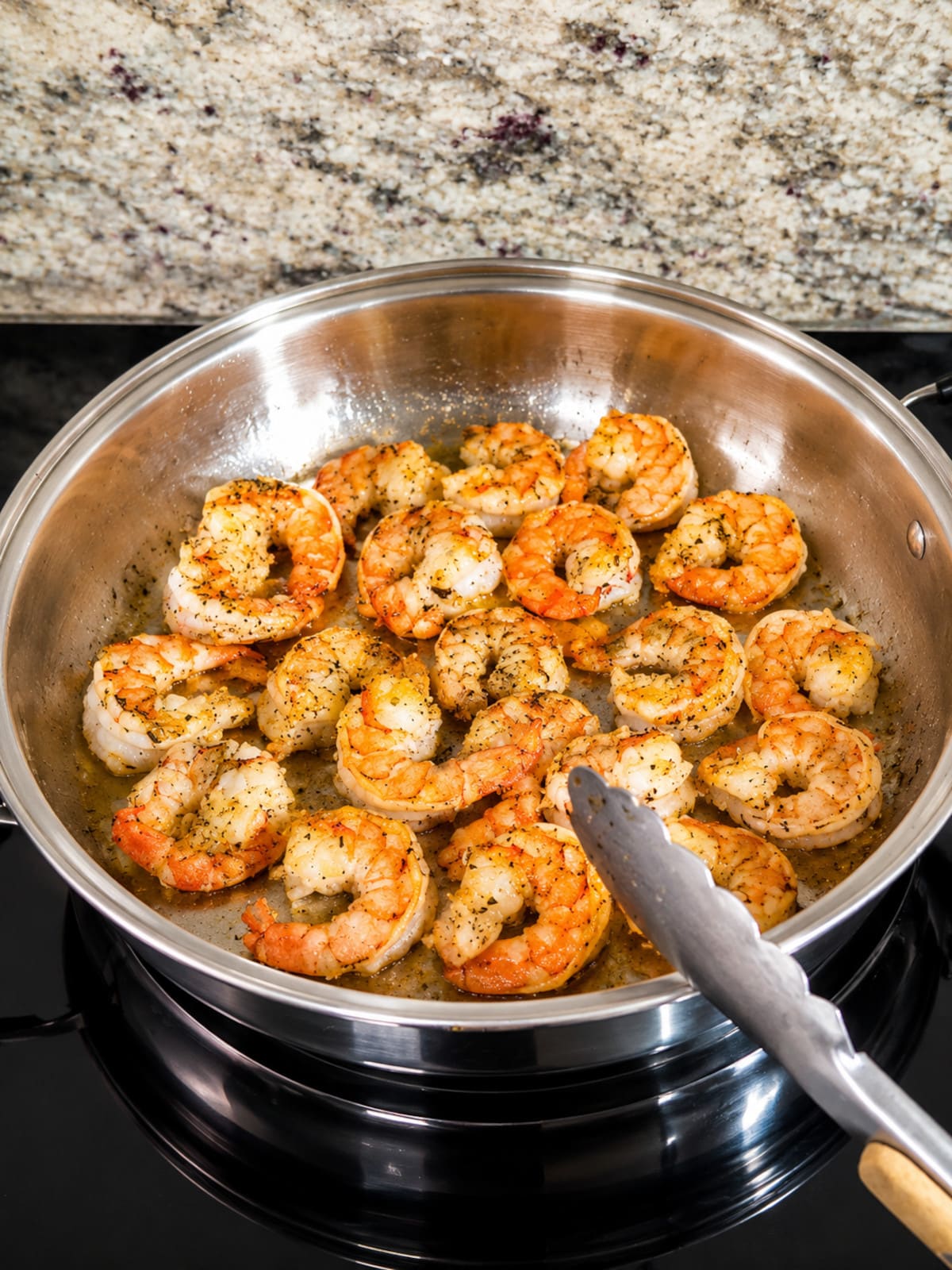 Shrimp cooking in stainless steel skillet.