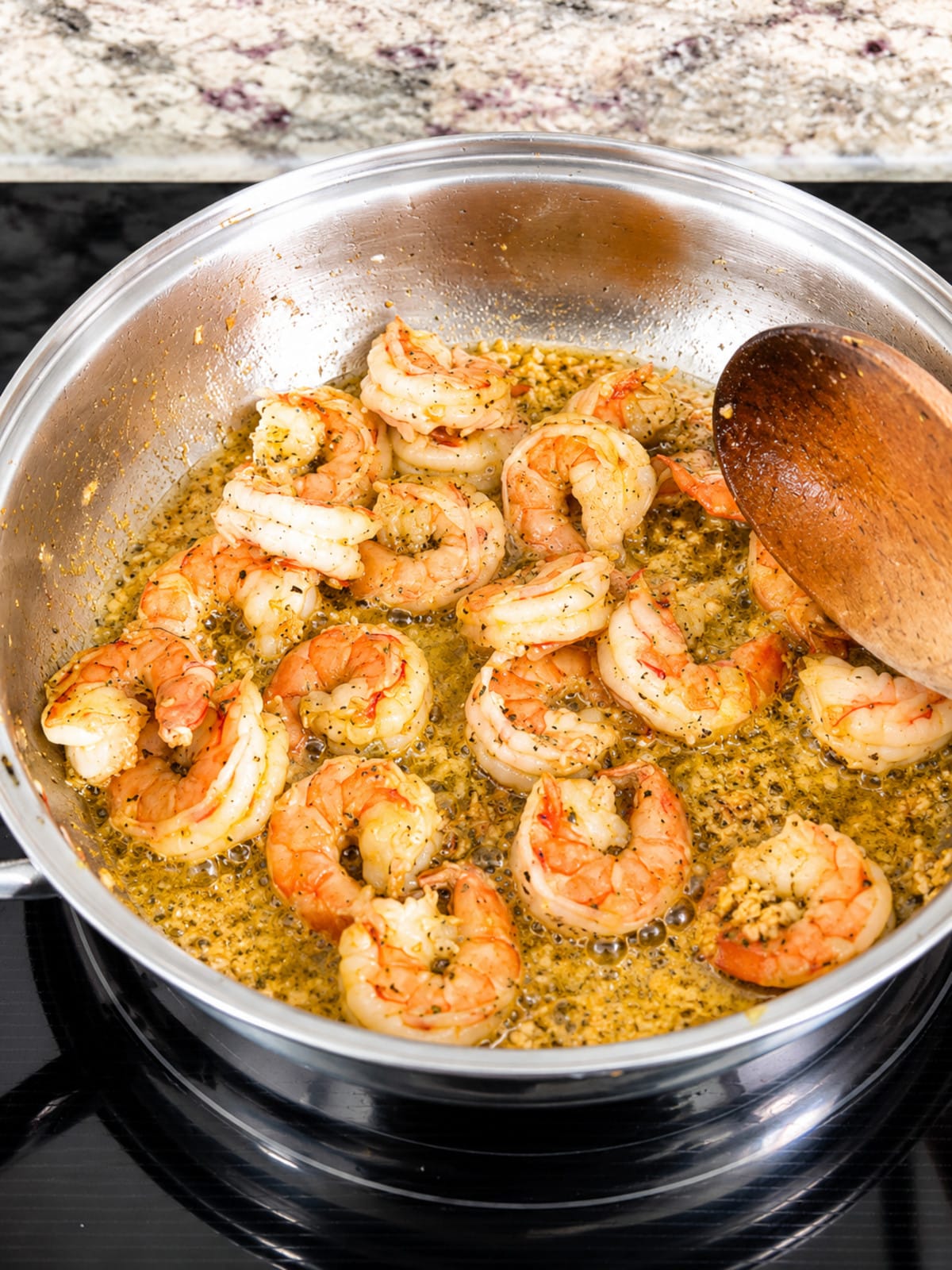 Easy garlic butter shrimp cooking in creamy garlic herb butter sauce.