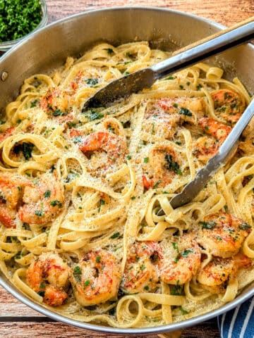 Creamy garlic butter shrimp pasta topped with Parmesan cheese.