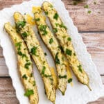 Roasted garlic Parmesan Japanese eggplant topped with fresh cilantro on a white serving platter.