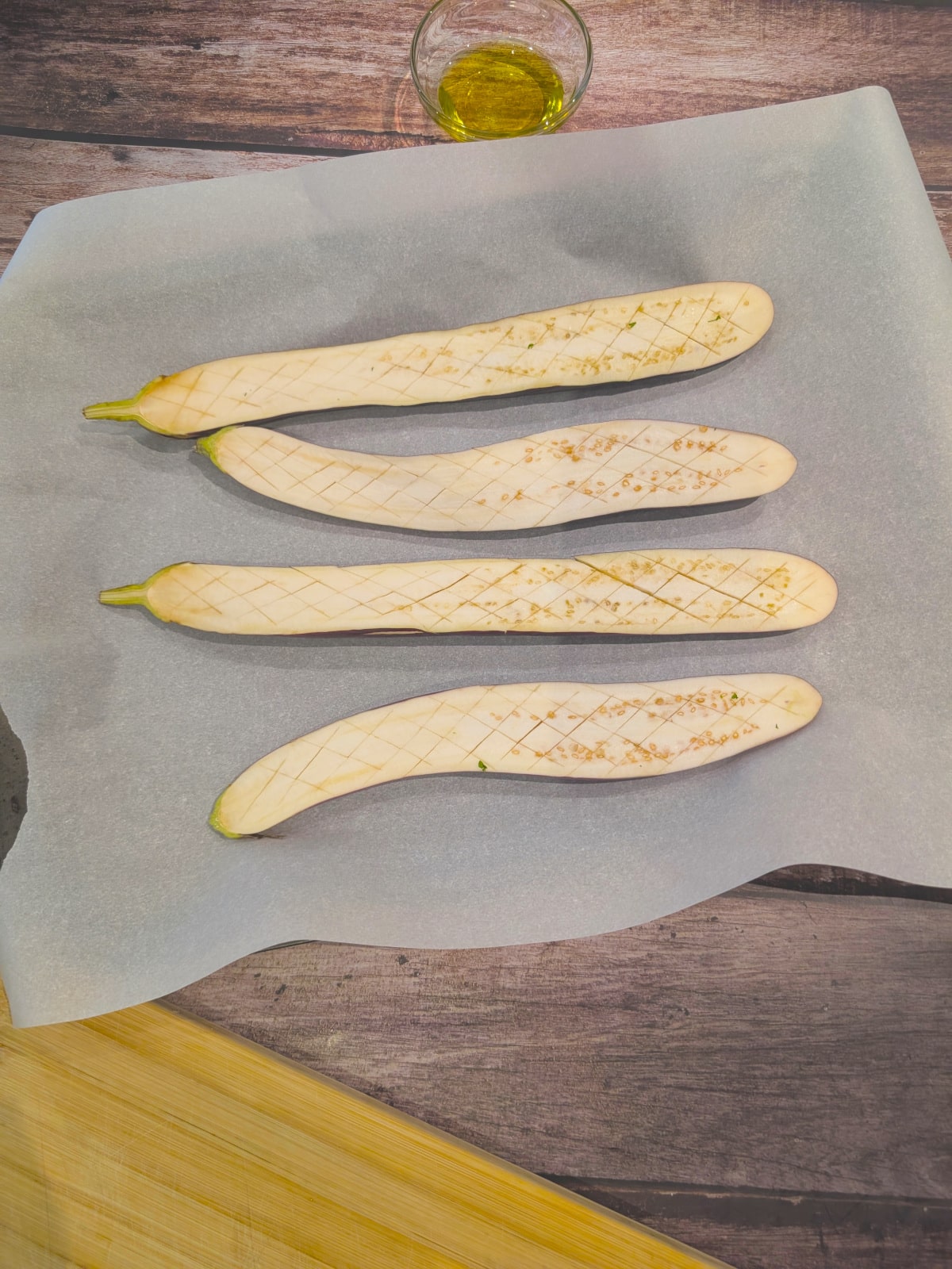 Japanese eggplant cut in half lengthwise and scored, ready for seasonings.