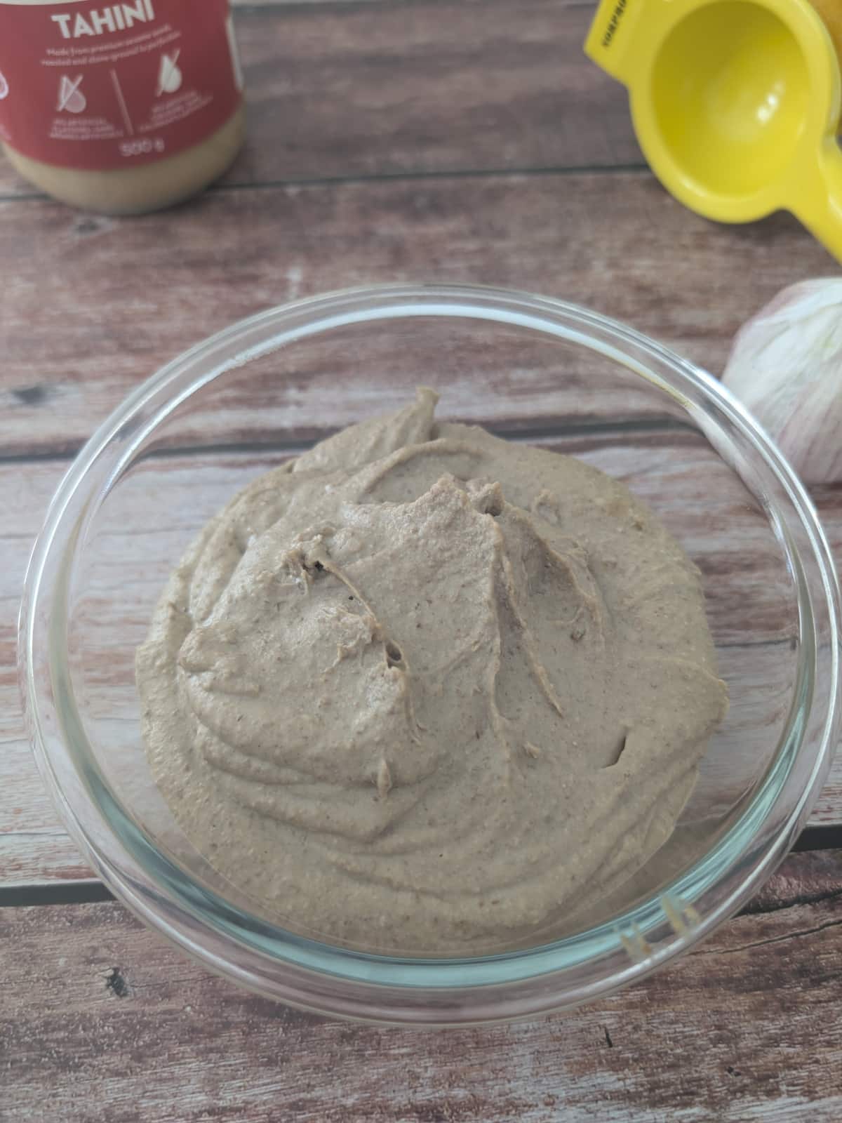 blended creamy lentil dip with tahini in a glass bowl.