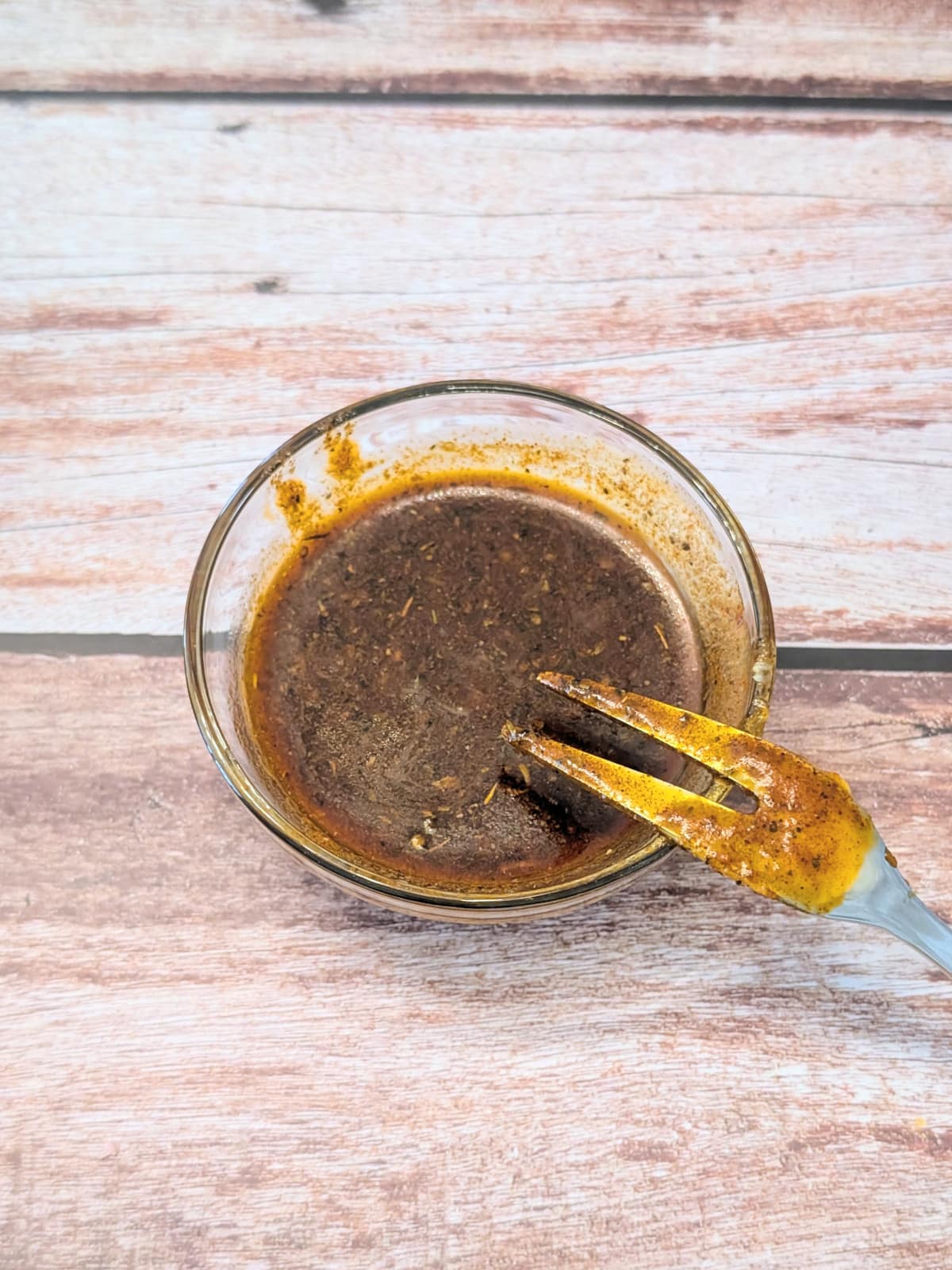 Butter herb seasoning mixture for oven baked chicken thighs in a small bowl.