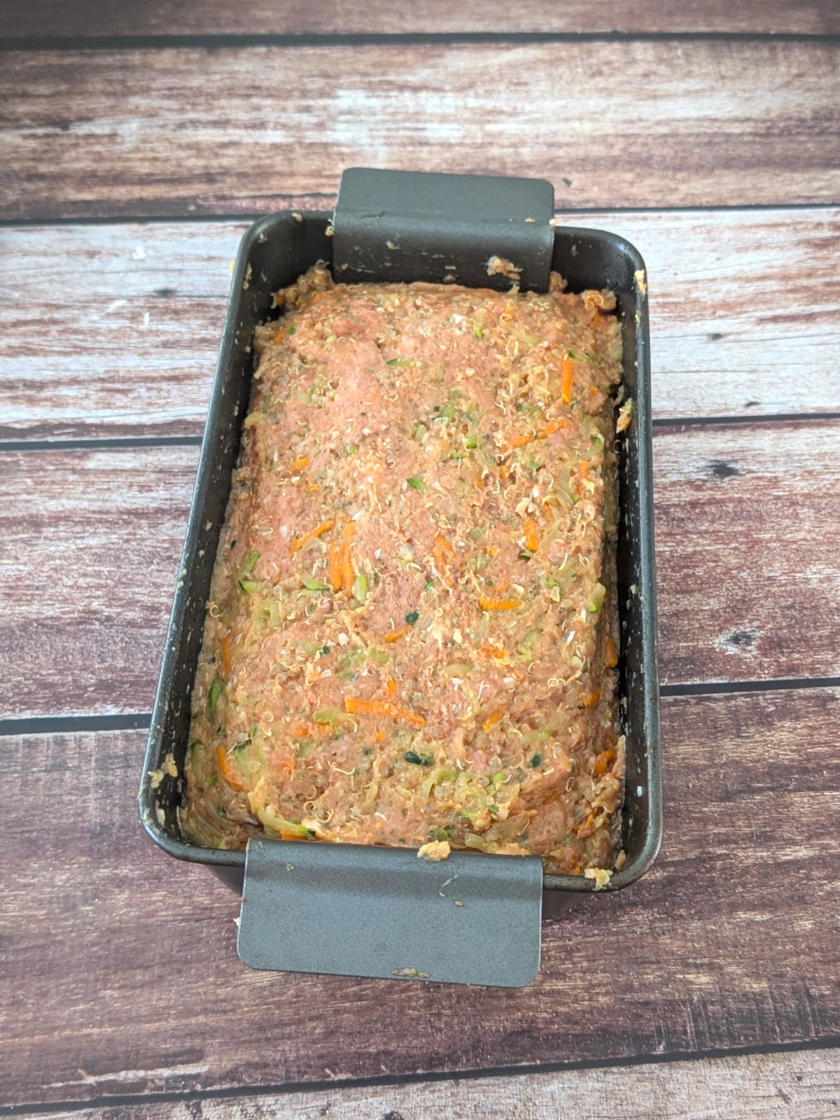 Turkey and chicken quinoa meatloaf mixture packed into loaf pan before baking.