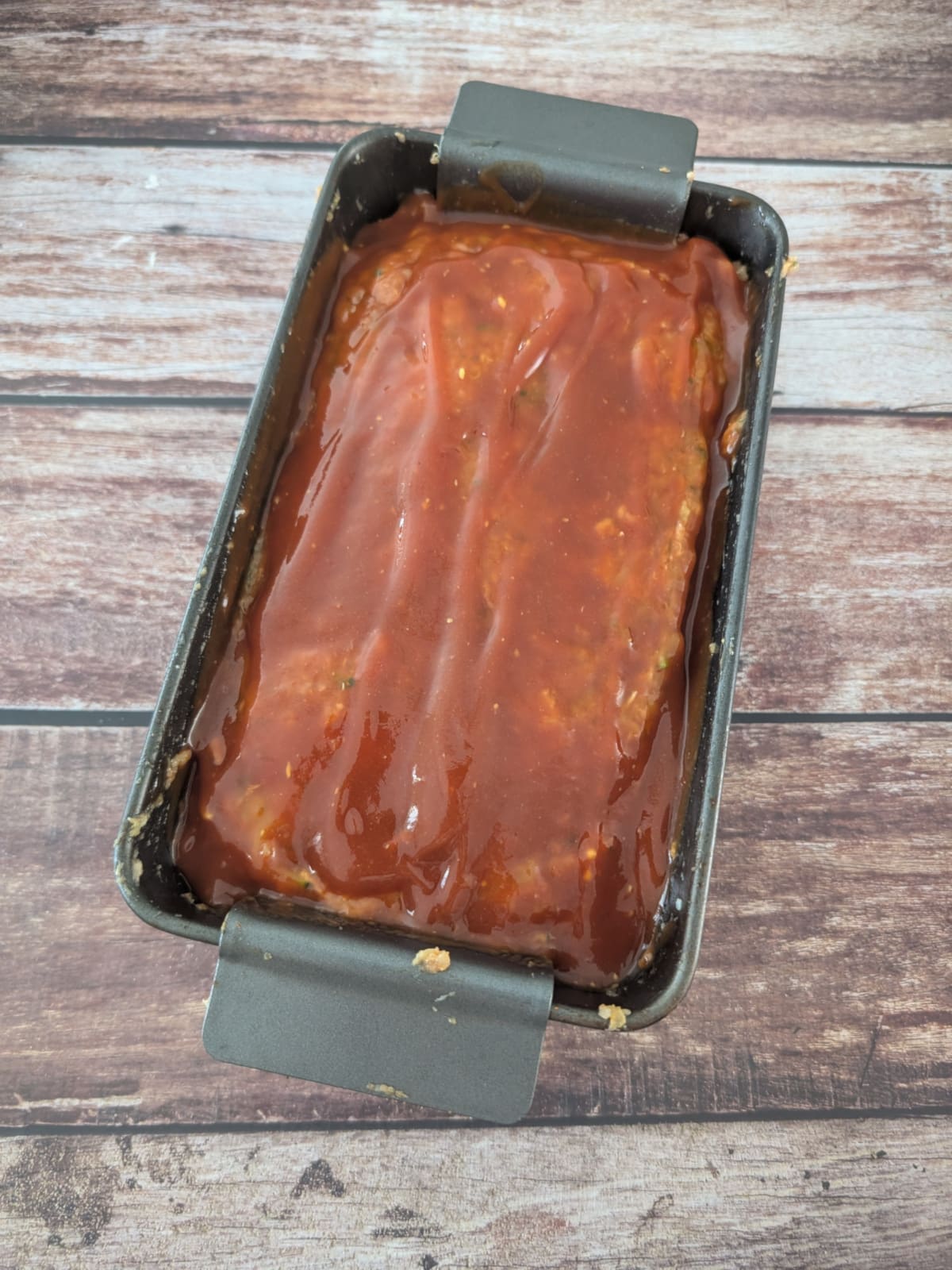 Quinoa zucchini meatloaf with homemade glaze ready for baking.