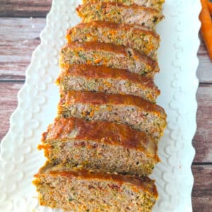 Juicy quinoa zucchini meatloaf sliced and served on platter.